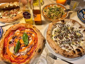 Various pizzas and Caesar salad at Al Catzone Pizza Napovegana in Berlin