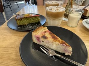 Vegan cheesecake with raspberries and pistachio cake. Two oat milk Cappuccino on the rocks 🧊  at Café August in Freiburg