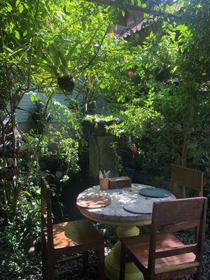 Table by koi fish and fountain  at Tasty Vegan in Seminyak