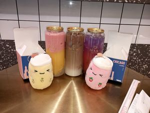 Sunrise slushie, oolong milk tea, and lemonade sandwiched between cute plushes at Te'amo Boba Bar in Chicago