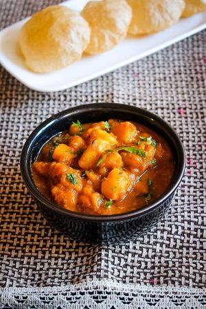  Punjabi Aloo Poori made with boiled potatoes simmered perfectly in spiced tomato gravy. Served with deep-fried puffed Indian bread. at Curry in a Hurry in Omaha