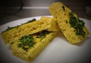 A popular delicacy from the Gujarati cuisine. It is light, spongy and includes a hint of great savory flavor from a simple combination of gram flour (besan), spices, and herbs.  at Curry in a Hurry in Omaha