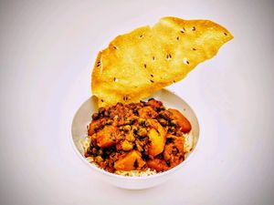 Aloo Mutter: Potatoes and peas in a spiced tomato curry sauce. Served with a side of Papadum. at Curry in a Hurry in Omaha