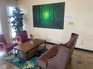 Beautiful vibrant green tree art and comfy velvet couch and chairs at Cup & Crêpe in Everett