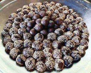 Dessert laddus with local ragi flour, palm jaggery, coconut oil, and sesame seeds. at Sadhana Forest Seva Kitchen in Auroville