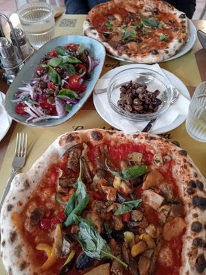 Marinara and vegetable vegan pizza with tomato onion salad with olives at La Napoletana in Taormina