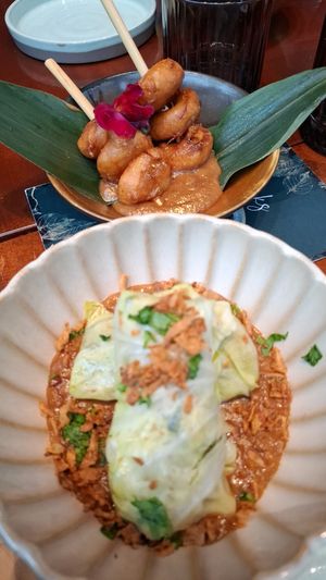 Twee voorgerechten; gadogado koolrolletjes en bakabana op een stokje. at Papa Aswa in Amsterdam