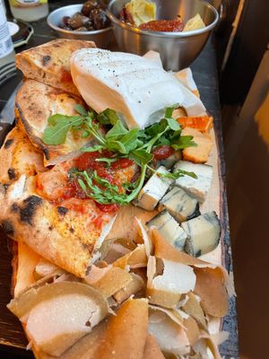 Board of cheeses, pastrami, mozzarella, bread and pizza at Retrogusto Experience in Lisbon