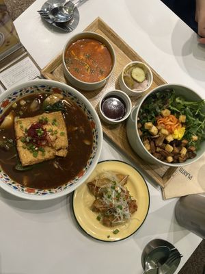Clockwise from top: Tomato soft tofu stew, bibimbap with crumble tofu, signature warm noodle soup with pine mushrooms. Plus the sides.  at Plantude 플랜튜드 in Seoul