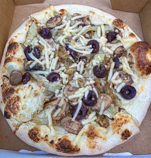 Pizza with cashew cream sauce, mozzarella, artichokes, mushrooms, olives and vegan sausage! Delicious.  at Plant Craft Kitchen in St Louis