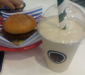 Spicy veg burger, and Skittles oat milkshake; one of 6 vegan flavours at Love A Slice in Beckenham