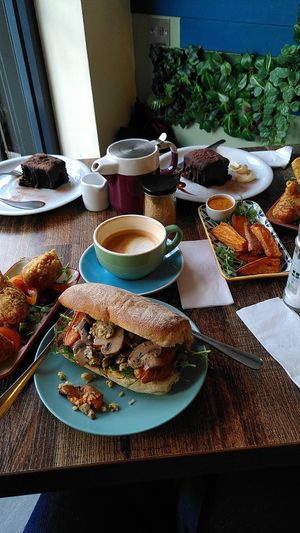 Sweet potato wedges with pickled  sliced carrots, red cabbage and a pea shoot garnish, curried cauliflower, and mushroom and stuffing ciabatta, oat latte, mocha chocolate cake at The Delightful Touch in Sheffield