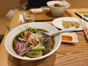 Black sesame ramen, with gyoza in background. at T's Tantan - Tokyo JR Station in Tokyo