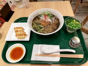 Black sesame ramen with gyoza and green vegetables at T's Tantan - Tokyo JR Station in Tokyo