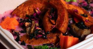 Homemade pink curry with black lentils and black chickpeas, curried squash, seasonal roasted vegetables, fried black kale, carrots and rose petals at The Vegan Witch in Cambridge