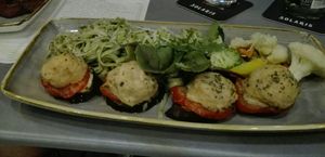 Vegetarian Melanzani-tomato-sheep cheese cake with fettuccini in green pesto and steamed vegetables at Gelbes Krokodil in Linz