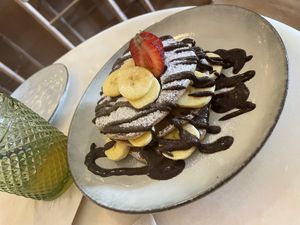 Apple oat pancakes with choco and banana 😋😋 if you are in choco mood perfect if not you Can choose Berry Sauce 🫐🍓  at SHOSH in Lisbon