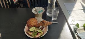 Breakfast with 4 items (cinnamon bun, rye bread, croissant, tea) at Encanto - Art Cafe in Helsinki