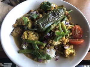 Indian cauliflower and chickpea (v) - roasted cauliflower chickpea and green beans in a rich Indian style curry sauce served with organic basmati rice garnished with diced red oni  at The Witches Brew in West Hempstead