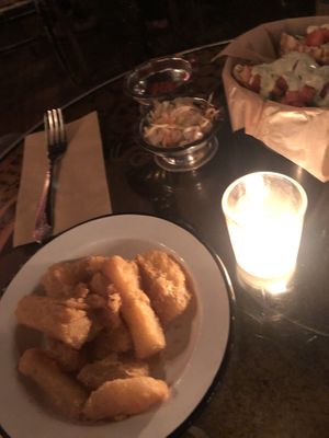 Yuga Frita - golden fried yuga topped with tangy and spicy coleslaw garnished with bacon bits and microgreens 
  at The Witches Brew in West Hempstead