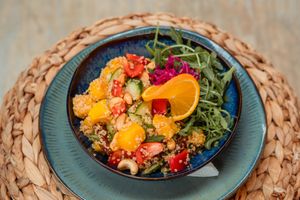Healthy quinoa bowl met sesamdressing, mango, komkommer, bosui, paprika, cashewnoten, zongedroogde tomaat en rucola at Makani Beach in Ter Heijde