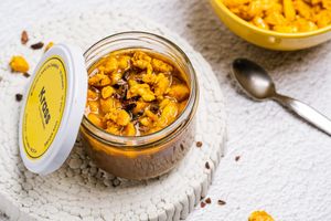 Alba: Our version of the traditional "porridge": oat flakes with almond drink and pure cocoa, homemade papaya jam and topping of caramelized almonds curry and turmeric, with cocoa nibs. at The Krass Corner in Tenerife