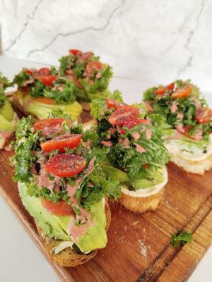 Sourdough bread with house humus, accompanied by abundant Avocado with kale and cherry tomatoes at Sin Karma in Santa Cruz
