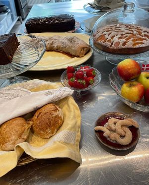 A selection of the café's baked goods - bread rolls, appel strudel, apricot cake, and a special Austrian chocolate cake with marmalade filling at Café Hyggestund' in Birkeroed
