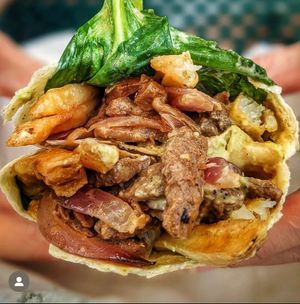 El Lomito Gordo-Peruvian marinated vegan steak sautéed with onions , tomatoes &cilantro, topped with fresh spinach, fries and house Inca sauce served inside of a grilled flour tor at RiCoQui Plant-Based Street Food in Charlotte