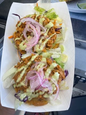 Loaded tostones- fried green plantain topped with fresh lettuce salad, marinated jackfruit, house Inca sauce and pickled onions at RiCoQui Plant-Based Street Food in Charlotte