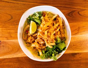 Enjoy our take on a Thai classic! Khao Soi is a sweet coconut curry with fresh noodles topped with crispy wonton strips and fresh veggies. Squeeze in the lime and add tofu for extra flair! at Cultivate Plant-Based Eatery in Rahway