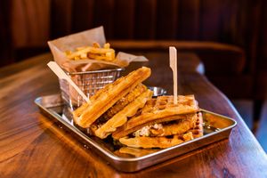 The chick 'n waffles sandwich is a brunch-y crowd pleaser! Topped with slaw and zingy maple glaze, with extra sauce for dipping, because it's just that good. at Cultivate Plant-Based Eatery in Rahway