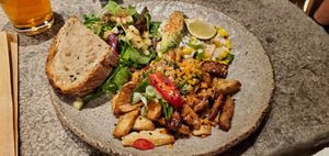 Spicy tempeh with "cheezy" corn, plus salad and toast. House IPA pictured top left. at Honest Greens - Gran Via in Madrid