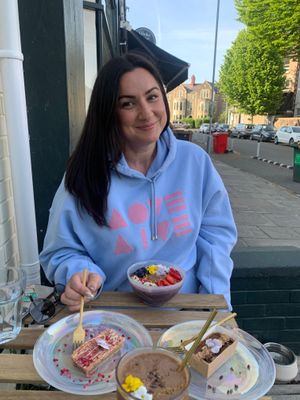 Wonderful Customers wearing the brand and eating outside. Acai Bowl, Blondie, CBD chocolate cake and Cacao Power Smoothie. All Vegan - Gluten Free - Refined Sugar Free  at Love Live Light Healing Hub in Cardiff