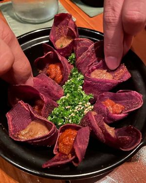a delightful combination of crispy purple potato curls paired with creamy edamame dip and a refreshing tomato-onion salsa at Cuca in Jimbaran