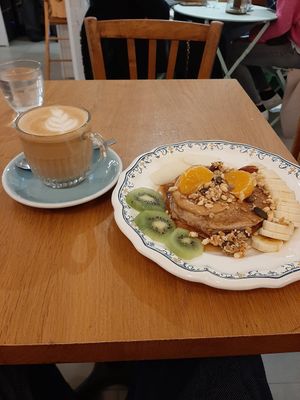 Latte et délicieux pancake sirop d'érable, beurre de cacahuète et fruits. at Ground to Grow in Paris