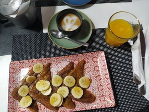 French toast with maple syrup and banana, oat milk cappucino and orange juice at Caffè dell'Arte Specialty Coffee in Cagliari