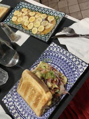 Vegan pancakes with maple syrup and banana. Hummus toast with veggies.   at Caffè dell'Arte Specialty Coffee in Cagliari