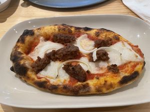 Complimentary vegan sausage pizza slice  at Vegano in Bangkok