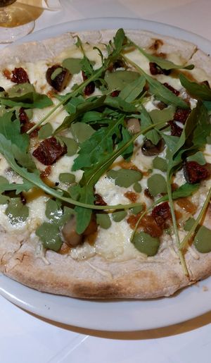 Pizza with dry tomatoes, caramelised onions and mussa at Humus Vegan Tenerife in Tenerife