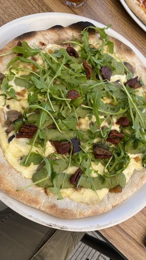 Pizza pestifera (mozzarella, basil pesto, caramelized onion, mushrooms, dried tomatoes and arugula).  at Humus Vegan Tenerife in Tenerife
