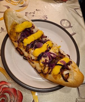 Baguette topped with red onion and cheese at De Vegan Bakker in Heusden