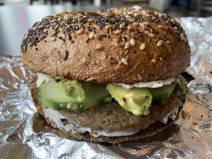 Harvest Grain bagel with vegan cream cheese, vegan breakfast sausage, avocado and cucumber  at Tandem Bagel Company in Florence