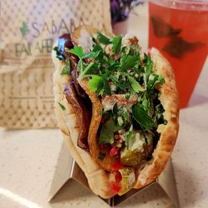 Amazing falafel pita wrap. I had it with fried veggies added and hibiscus lemonade. at Sababa Falafel Shop in Garden Grove