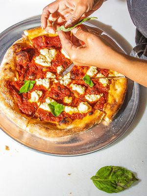 crushed tomato pizza w san marzano tomato, basil and almonds at Everyday Pizza in Denver