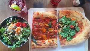 Two different vegan pizza slices and salad at VITO Europaallee in Zurich