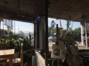 View from outside tables. Souvenir shop next door  at The Juice Bar by Bajo Bloom in 