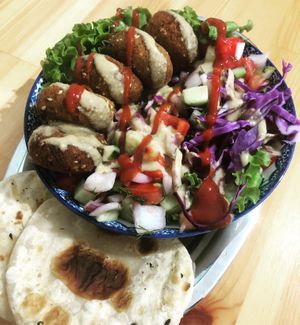 House falafels, bed of fresh red cabbage, diced tomatoes, onion cucumber, dill & lemon. Drizzle of house made tahini dressing, (Tahini made by us. Turned into dressing)
 at Green Life Market in Sarande