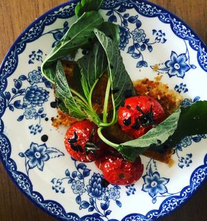 Farinata de ceci, which is Italian chickpea flour pie. Slow roasted cherry tomatos, red wine balsamic reduction drops & rural dark greens accompanied. at Green Life Market in Sarande