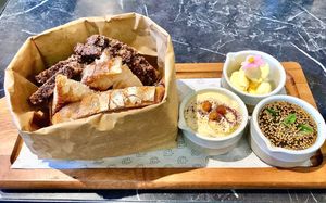 Bread bag with hummus, butter and zataar  at Pawdy Neighbors  in Dubai